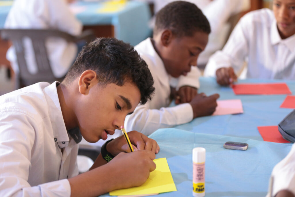 12 November (Ghat) Libya. Roken- 14 years old, pens his thoughts during an exercise on critical thinking, his concentration reflecting the diligent pursuit of problem-solving skills at the Life Skills session in Ghat. Photo: Abdullah Hussein/ UNICEF Libya.